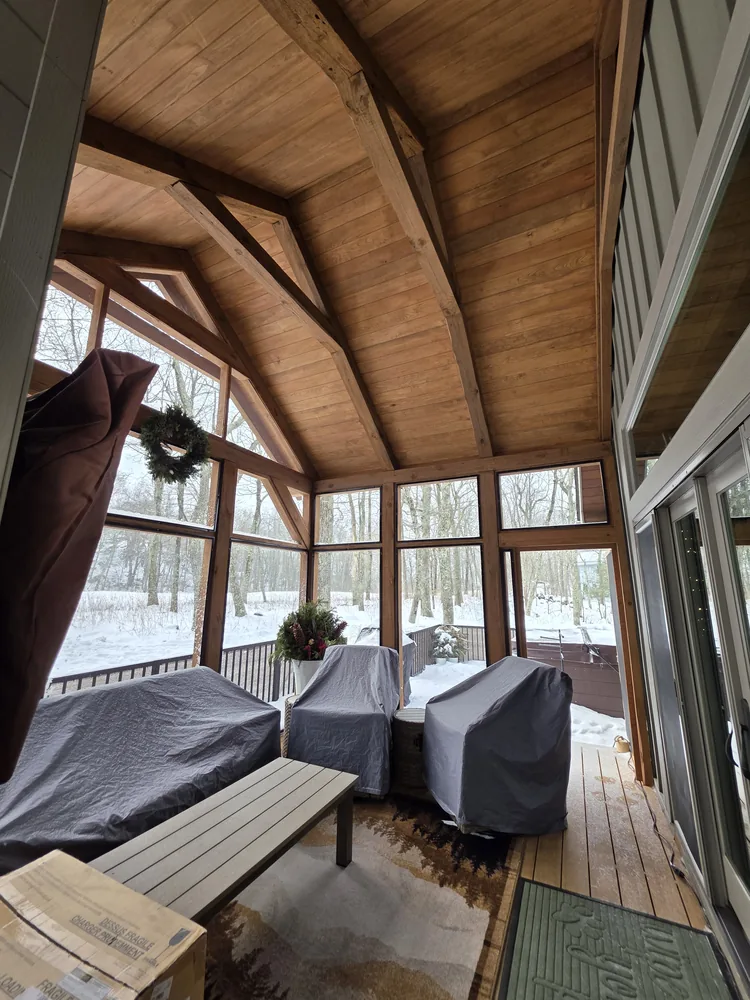 Timber frame porch interior with vaulted wood ceiling