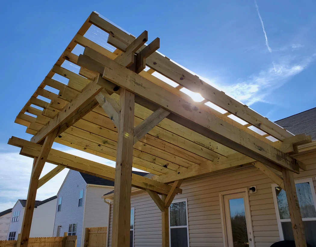 Custom pergola framing over a backyard patio