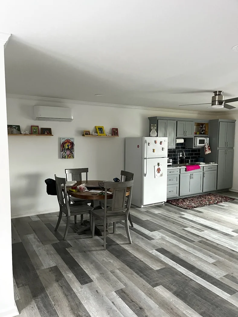 Finished kitchenette with gray shaker cabinets, black subway tile backsplash and wood-look vinyl plank floor