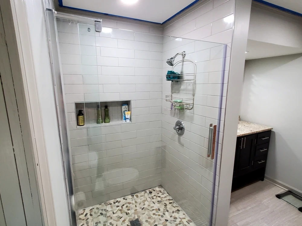 Bathroom remodel with a glass walk-in tile shower and a built-in niche